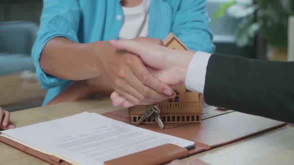 Close Up Of Male's Hand Shaking With A Hand Of Real Estate Agent After Signing On House Purchase Con