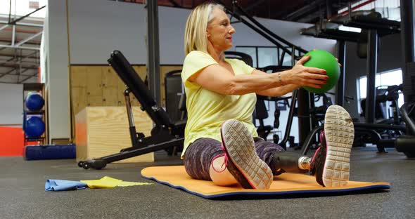 Senior woman doing oblique exercises on exercise mat 