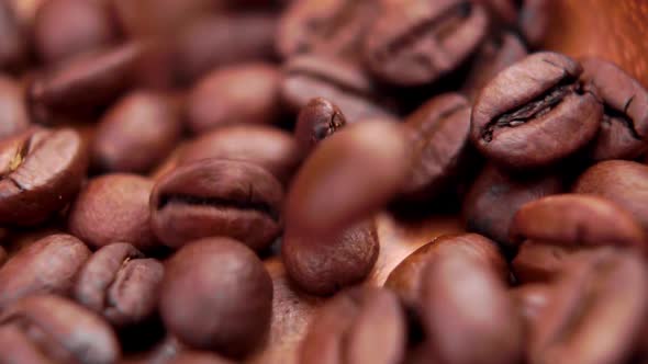 Freshly roasted coffee beans. Fragrant dark seeds falling in slow motion. Macro