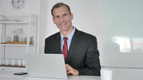 Portrait of Smiling Middle Aged Businessman Looking at Camera