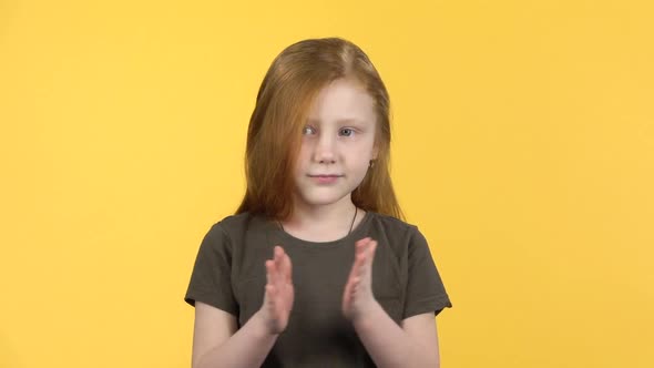 Pretty Girl Claps Happily on Yellow Background. Slow Motion