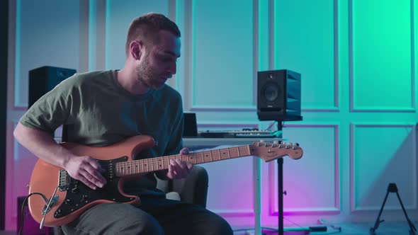 Man plays guitar in professional music studio. Man plays a musical instrument. Musician records