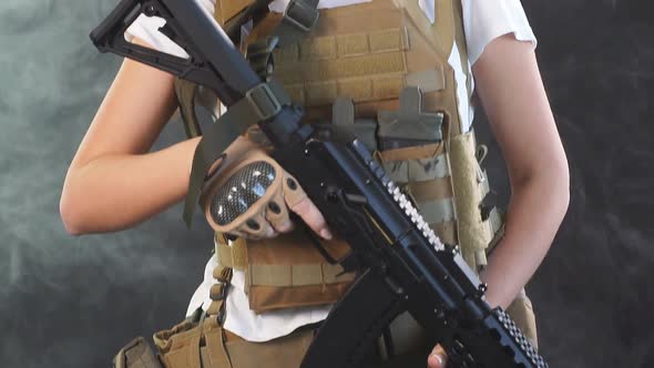 Young Blonde Female Snipper in Military Outfit with Assault Rifle in Studio