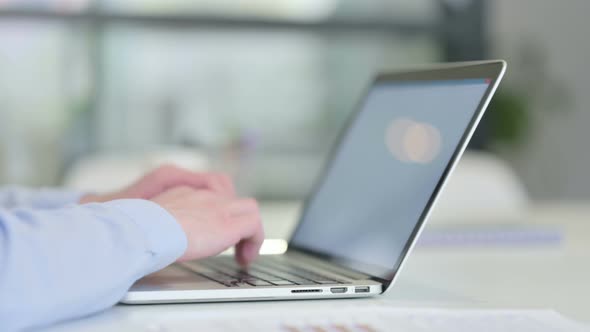 Close Up of Young Man Typing on Laptop