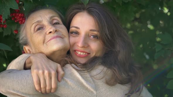 Happy Senior Mother in Eyeglasses is Hugging Her Adult Daughter the Women are Enjoying Together