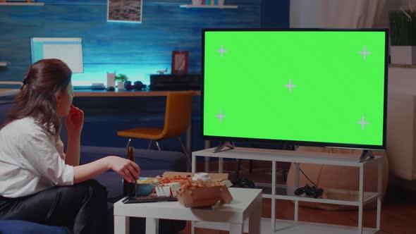 Young Person Watching Green Screen on TV in Living Room