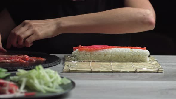 Japanese Chef Prepares Sushi Rolls with Salmon and Avocado