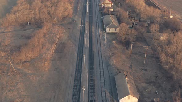 Empty Railway Station with Rails and Small Buildings  Tilt Reveal Drone Shot