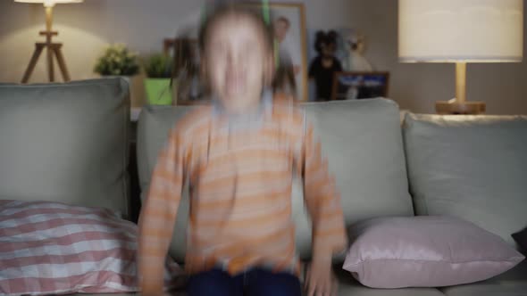 Little Girl Child Sitting On Sofa At Home