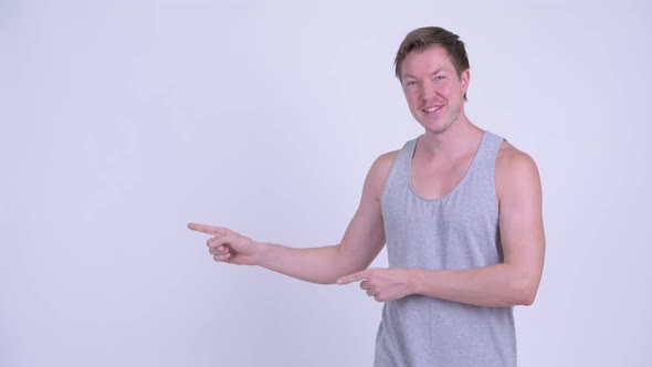 Happy Young Scandinavian Man Pointing Finger and Showing Something