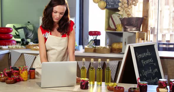 Female staff using laptop on counter