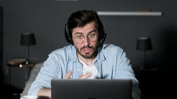 Young business man using laptop video conference talking to colleagues meeting online