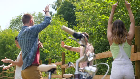 Happy Friends with Bicycles Dancing at Summer Park 