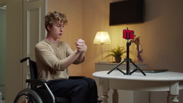 A Young Disabled Man is Making Hand Exercises