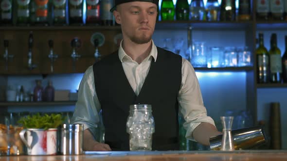 The Bartender Begins To Prepare an Alcoholic Cocktail.