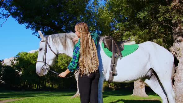 A Teenage Cowgirl Stroking a Horse