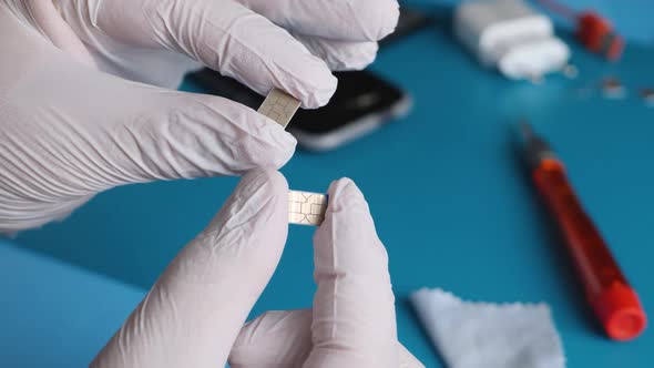 Equipment Engineer Hand in White Gloves Hold and Look nanoSIM Cards