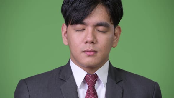 Young Handsome Asian Businessman Relaxing with Eyes Closed