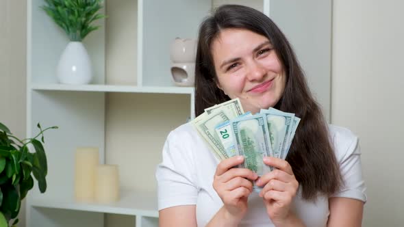 A Happy Woman Throws Up a Lot of Bills of Dollars and Euros and Laughs