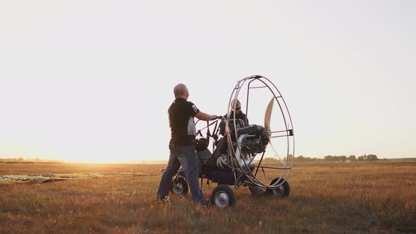 The Motor Paraglider Stands in the Field at Sunset with a Wooden Propeller