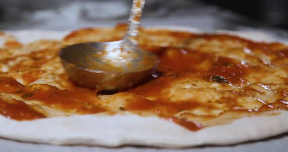 Process of spreading sauce on pizza dough