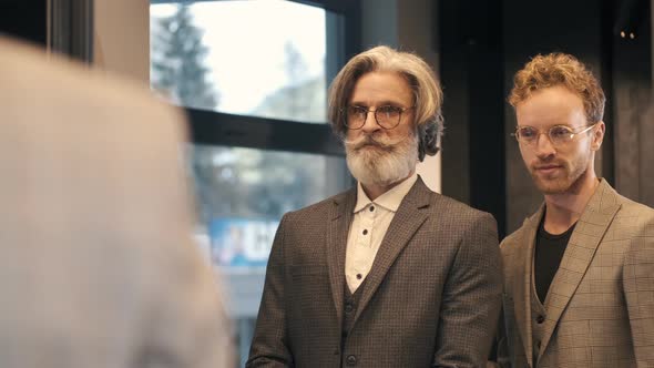 Man Trying Business Suit on with Consultant at Men Clothing Store