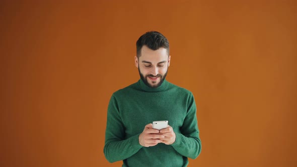 Portrait of Attractive Hipster Playing Video Game on Smartphone Touching Screen