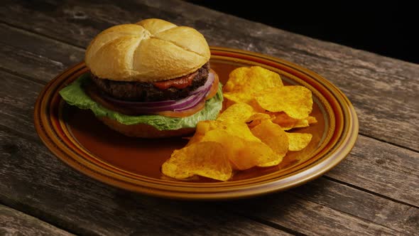 Rotating Shot of Delicious Burger and Potato Chips