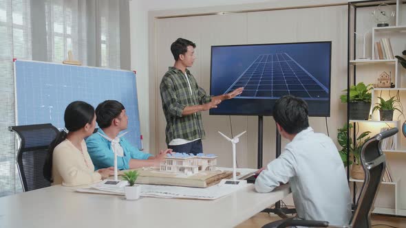 Asian Man Engineer Presenting About The Work Of Solar Cell To His Colleagues At The Office