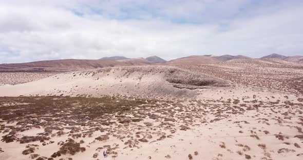 Path road in the middle of a mountains sand desert with blue bright sky in background. Arid climate