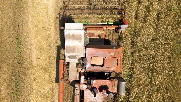 Farmer Rides an Old Combine to Work