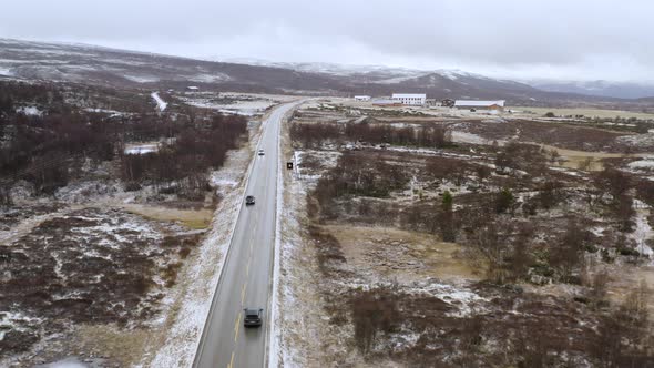 Vehicles Driving In The Road During Winter Near Dovre Municipality In Norway. - aerial