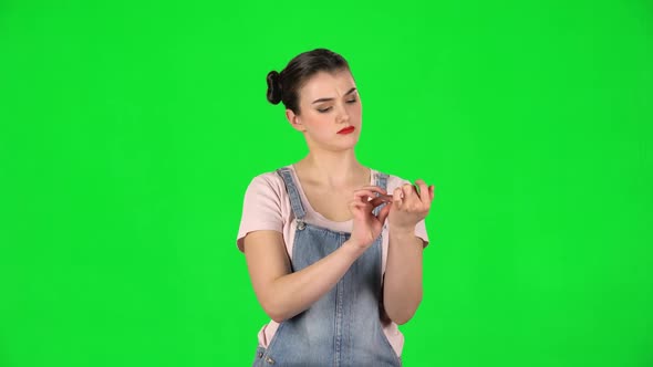 Girl with Two Hair-buns and Red Lips Makes Herself Manicure with Pink Nail File