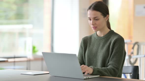 Young Woman with Laptop Smiling at the Camera 