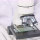 Female Lab Technician in Rubber Gloves Adjusts Focus of Microscope Close Up - VideoHive Item for Sale