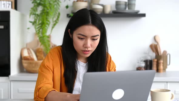 Successful Happy Emotional Chinese Girl in Stylish Clothes Freelancer IT Specialist Sitting at Table