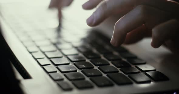 Woman typing at a laptop keyboard