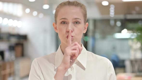 Portrait of Young Businesswoman Putting Finger on Lips, Quiet Sign 