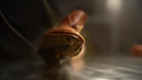 Closeup of Shoemaker in Black Gloves Spraying Paint of Light Brown Leather Shoes