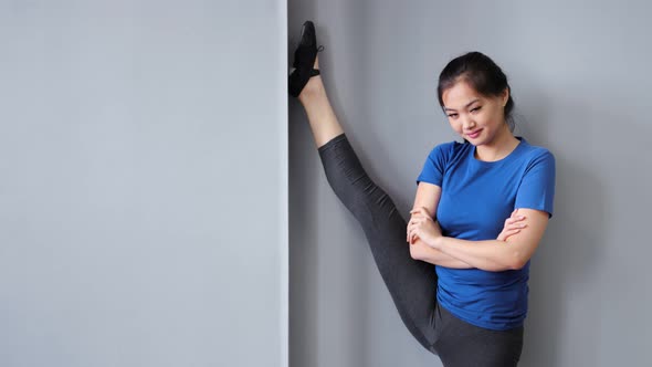 Smiling Asian Professional Ballet Dancer or Pilates Woman Showing Amazing Stretching