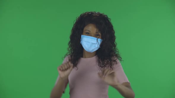 Portrait of Beautiful African American Young Woman in Medical Mask Is Looking Straight and Is