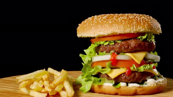 Craft Beef Burger and French Fries, Sauce Isolated on Black Background. Fast Food