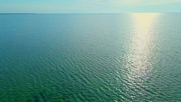 Calm Clear Sea with Sun Reflection Filmed From Drone