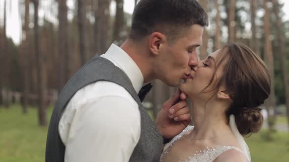 Newlyweds Caucasian Groom with Bride Walking Embracing Hugs in Park Wedding Couple