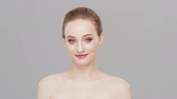 Studio portrait of young, beautiful and natural woman over grey background.