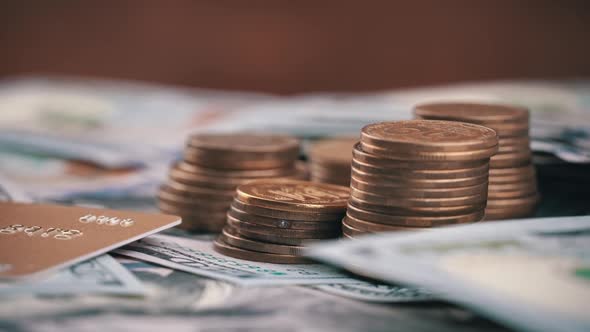 Columns of Coins are Spinning Against the Background of One Hundred Dollar Bills