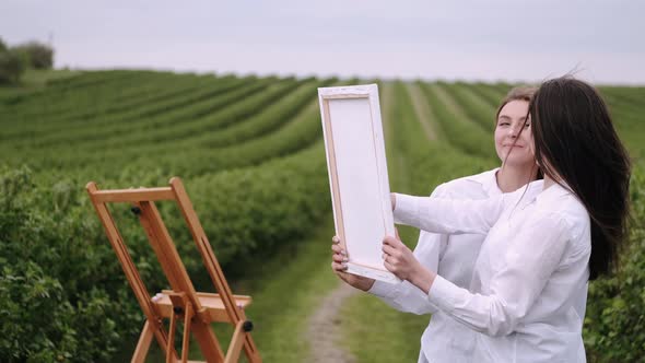 Elegant and Beautiful Girls Painting in a Field