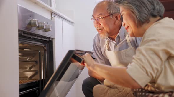 Asian senior older couple grandparent make pizza in kitchen at home with smile enjoy family activity