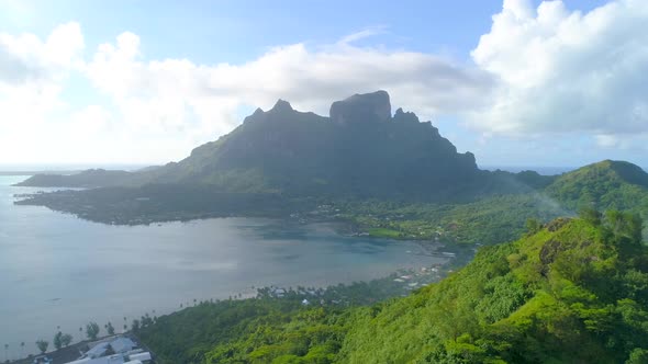 Aerial drone view of a luxury resort and overwater bungalows in Bora Bora tropical island.