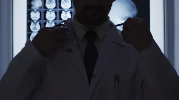 Doctor putting stethoscope around his neck